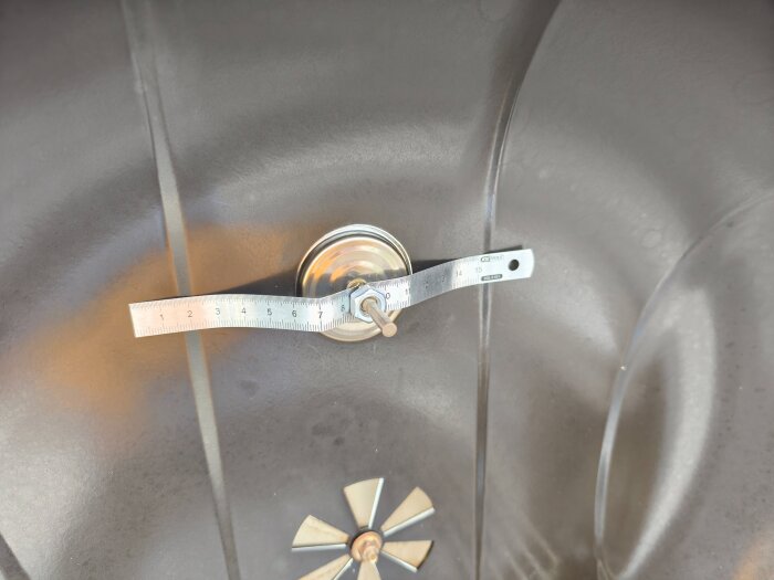 Grilltermometer fäst improviserat med metallbit och bult i grillens lock.