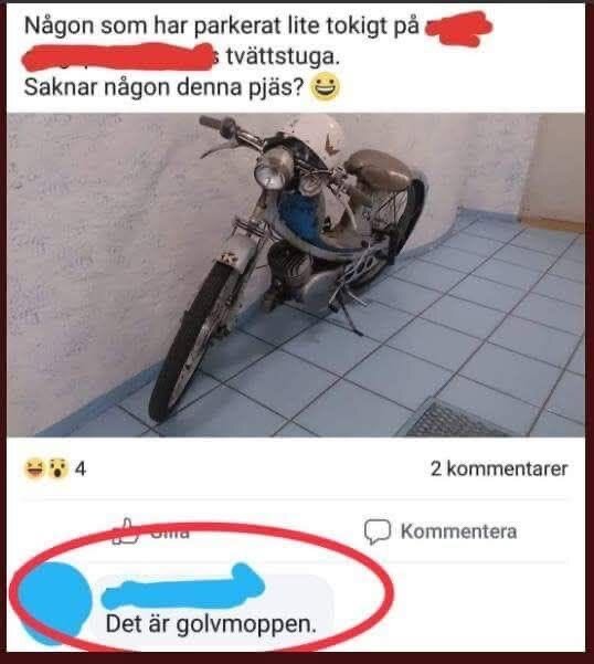 En motorcykel står i en tvättstuga vid en vägg med ljusblått kakelgolv och ett skämt om golvmoppen i en kommentar.