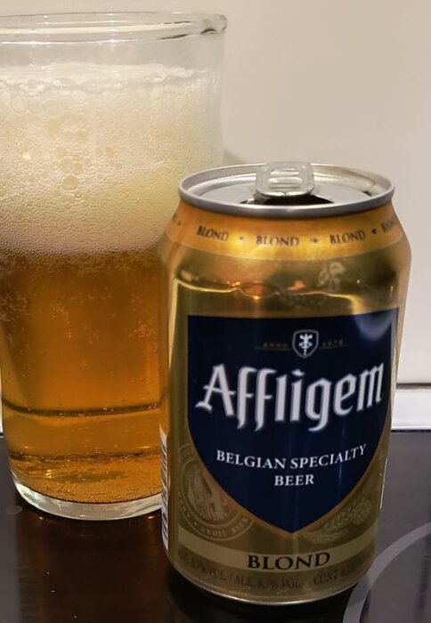 Ölburk Affligem Blond framför ett fyllt ölglas.