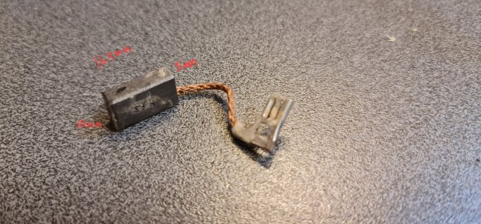 Kolborste med kabel och kontakt från sänksåg Bosch GKT 55 GCE. Kolborsten mäter 16,7 mm i längd, märkt med dimensioner i röd text.