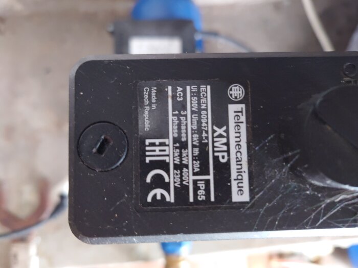 Närbild på etikett av en elektrisk komponent från Telemecanique med specifikationer som IEC/EN 60947-4-1, partnummer, tillverkningsland och skyddsklass IP65.