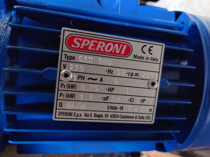Närbild på en informationstavla på en blå Speroni vattenpump, modell CAM 100, specificering: 230V, 50Hz, 2850 rpm, tillverkad i Italien.
