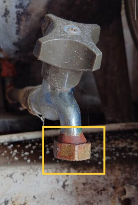 Rostig metallventil på ett rör i närbild, sannolikt del av ett hydroforsystem för justering av luftkudde i tanken.