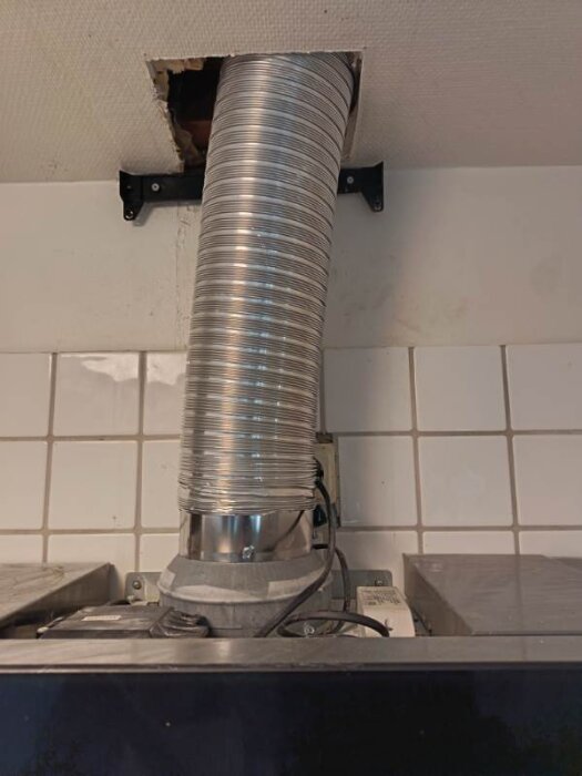 Ventilationskanal installerad genom tak med avtagna takplattor för åtkomst.