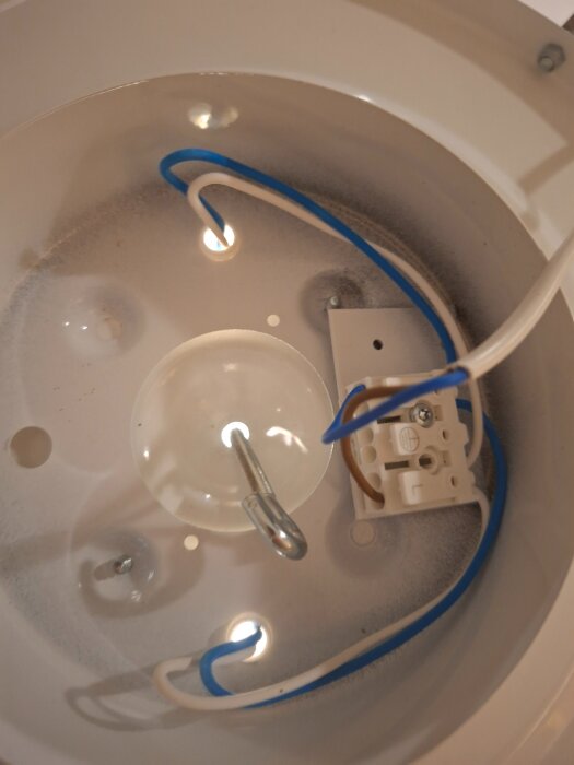 Lampsockel med blå och vita kablar, kopplingsplint och fäste i tak, del av lampinstallation diskuteras.