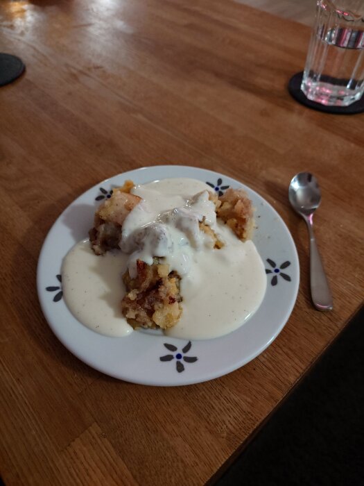 Äppelpaj med vaniljsås serverad på en tallrik.