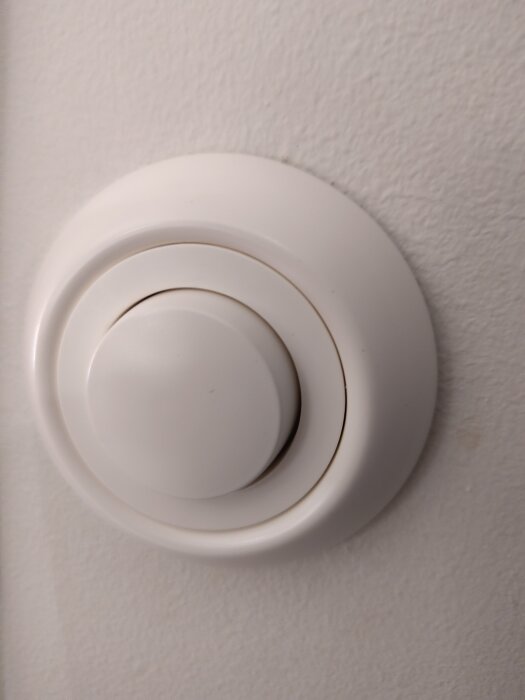Vit dimmer på vägg med lösa ringar och övre delar, vredet sitter fast men resten skramlar, söker instruktioner för återställning.