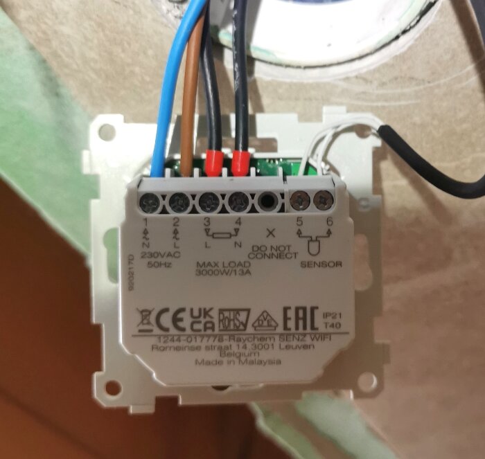 Elektrisk golvvärmetermostat med anslutna kablar.