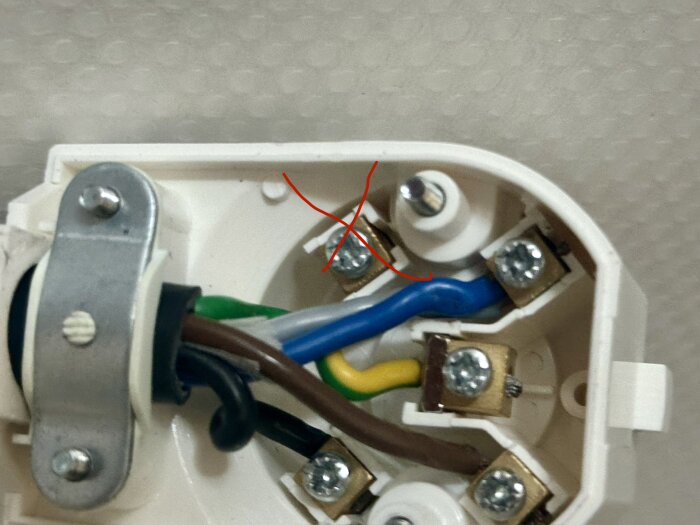 Anslutningar i en elektrisk kopplingsdosa med markerade kablar och skruvar, del av installation för inbyggd häll och ugn.