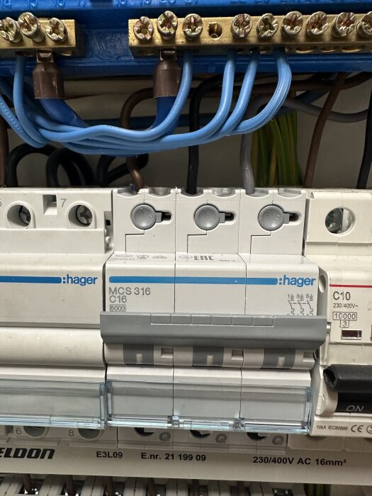 Bild av elcentral med tre instoppade Hager MCS 316 C16 säkringar och en C10 säkring, elektriska kablar anslutna ovanför.