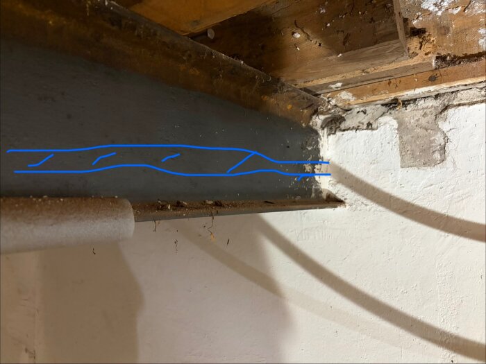 Stålbalk i taket med blå linje markerad, en fråga om att limma eller skruva en regel vid sidan för att fästa gips.