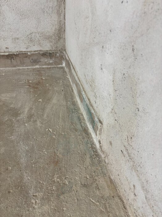 Betonggolvsockel i källargarage med avsliten kant, visar var ny del ska monteras för renovering.
