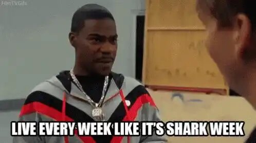 Man i en huva pratar med någon, text: "Live every week like it's Shark Week" i nederkanten av bilden.