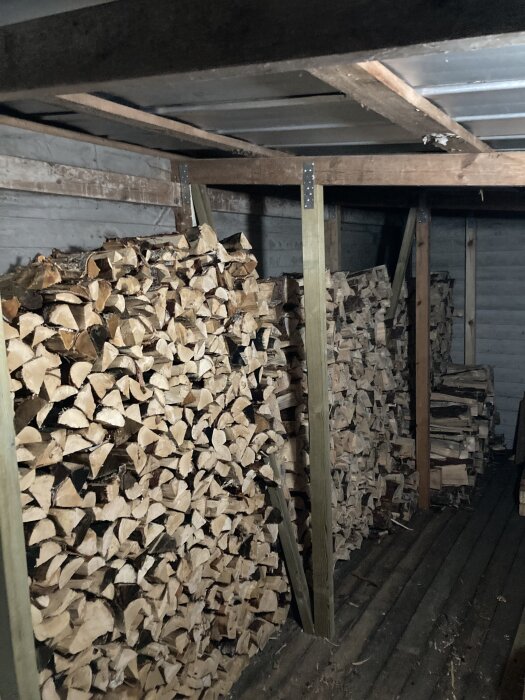 Staplad ved i förvaringsutrymme med trätrallgolv.