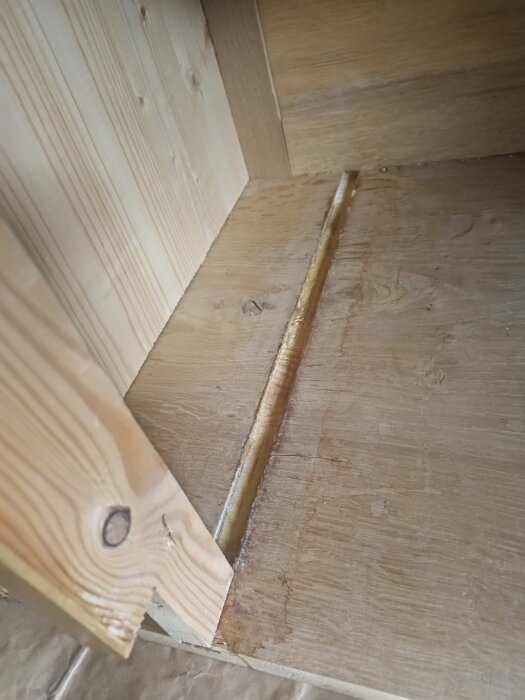 Träytor av en gammal kommod med en trälist i ett gradspår, del av en renovering där listerna behöver ersättas.