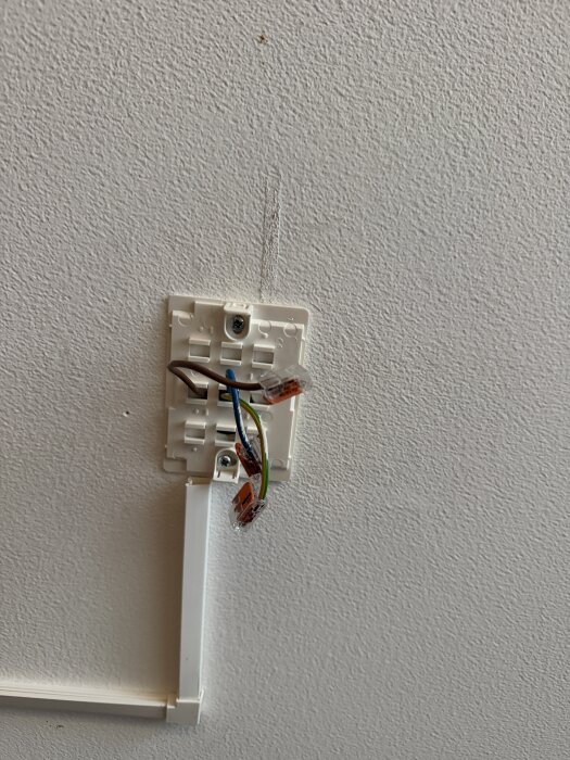 Elektrisk anslutning i taket med blå och bruna kablar anslutna i wago-kopplingar, samt en grön-gul jordkabel i chassit.