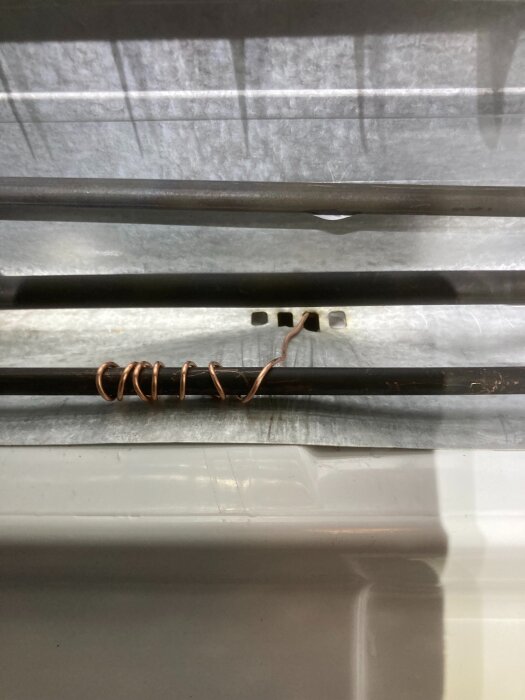 Koppartråd lindad runt en värmespiral för att förhindra att ett dräneringshål fryser igen.