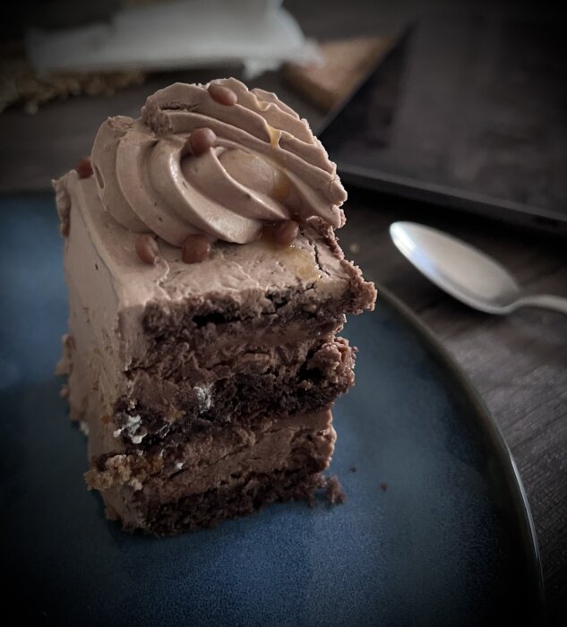 Chokladbakelse med chokladsmörkräm, chokladbottnar och daimkulor på en blå tallrik, en del av en "gottefika" insats.