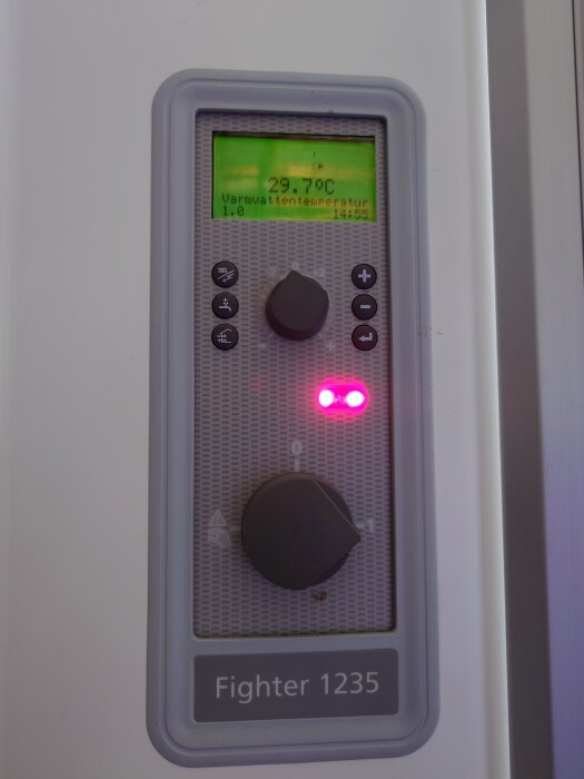 Närbild av kontrollpanelen på en bergvärmepump, Fighter 1235, med temperaturdisplay som visar 29,7°C och blinkande varningslampor.