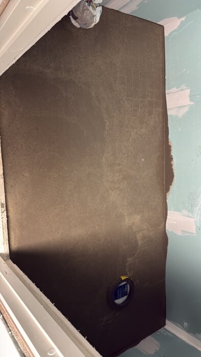 Nyflytspacklat betonggolv i ett badrum med en inbyggd avloppsrörsinstallation.