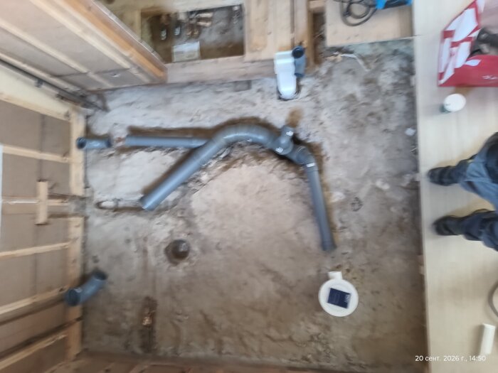 En skiss av avloppsrör och golvbrunnar på en byggarbetsplats under renovering, med rör utlagda i ett öppet golv.