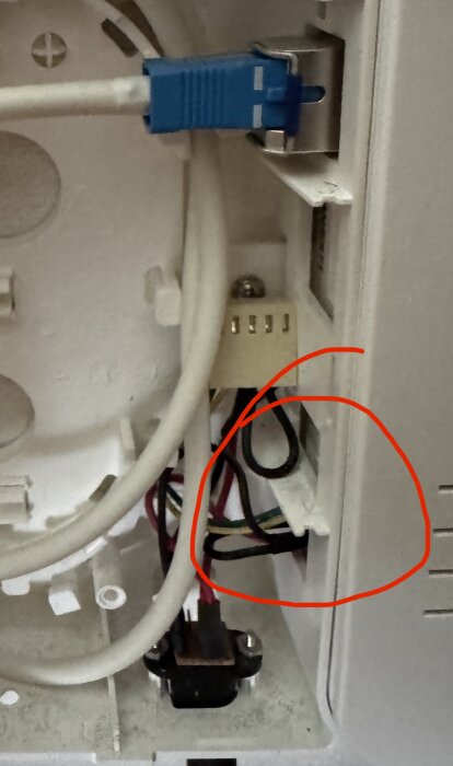 Elektrisk anslutningsbox med kablar, en blå kontakt och en delvis synlig röd cirkel markerar specifikationspunkt.