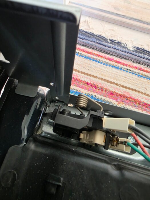 Närbild av ugnslås och sensor på en Electrolux-ugn, visar plats för öglor som känner av om luckan är stängd.