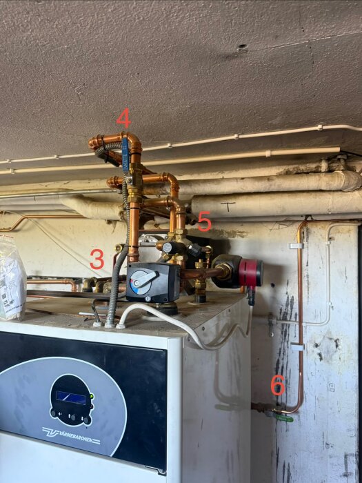 Pelletsbrännare med rör och ventiler markerade med nummer, inklusive säkerhetsventil och cirkulationspump. Installation i husets uppvärmningssystem.