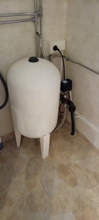 Hydropress i ett badrumshörn med ledningar, avsedd för uppgradering.