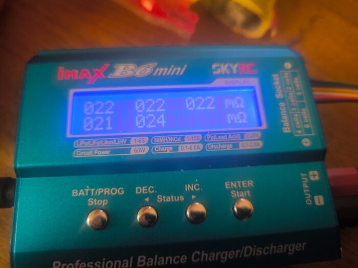 IMAX B6 mini laddare som visar spänningsvärden och inre resistans för ett batteri, med display med blå bakgrund.
