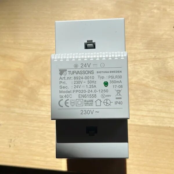 Tufvassons transformator 24V, modell FP020-24.0-1250, vit konstruktion med tekniska specifikationer och symboler synliga på framsidan.