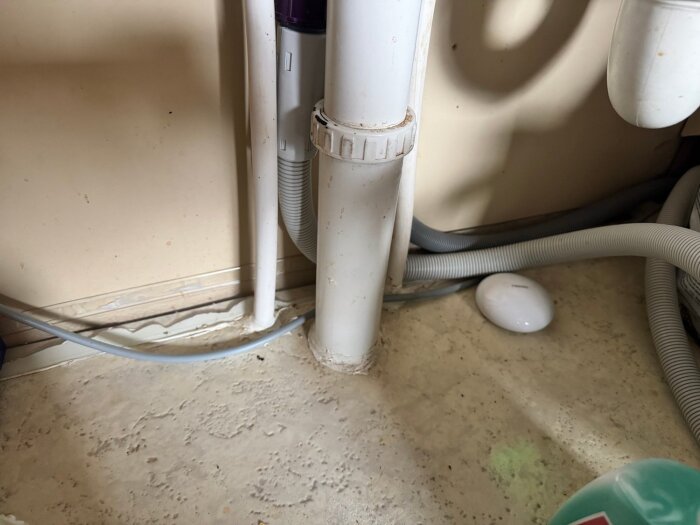 Under diskbänken med våtrumsmatta, silikonfogar och vattenvarnare nära rör och anslutningar.