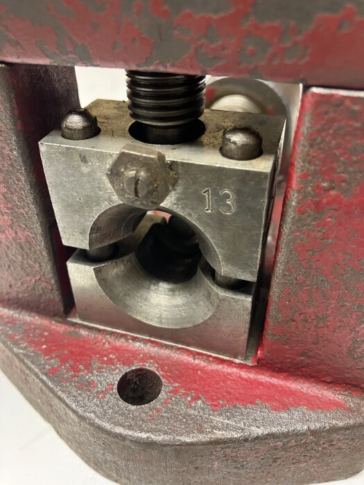 Rengjord komponent i metall, FORMAX 20, med synliga styrstift och en markerad blå pil för kullagrad rulle. Märkning "13" synlig på ytan.