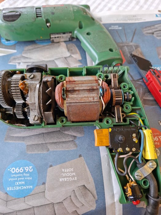 Grön borrmaskin från 1988, öppen för reparation med synliga komponenter och intern mekanik.