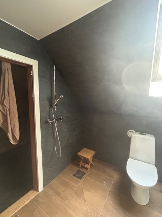 Badrum med snedtak, dusch, stol och bastudörr; förslag på skydd för att bevara dörrlisten efterfrågas i tråd om renovering.