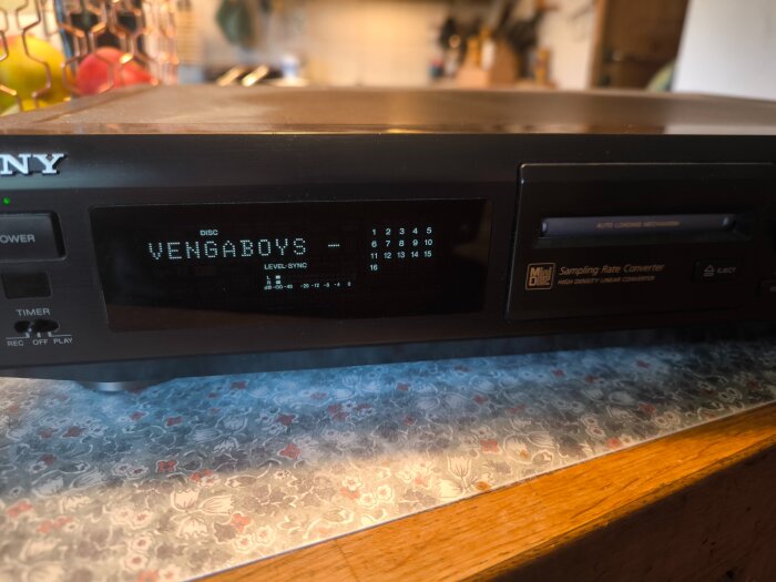 Sony MiniDisc-spelare med digital display som visar "Vengaboys" i ett kök med dekorativa bänkskivor.