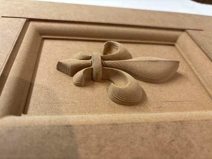 Ingraverat träpanel med dekorativt detaljerat bladmönster, skapat med CNC-maskin.