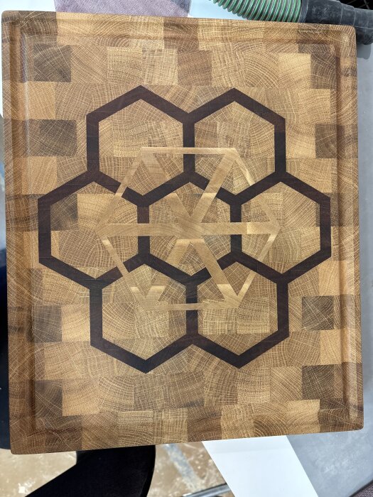 Träskärbräda med geometriskt mönster av hexagoner och trianglar, skapad med CNC-maskin.