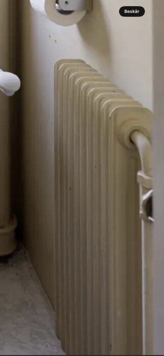 Suddig bild av ett gammalt element med flera sektioner placerat mot en beige vägg i ett hus.