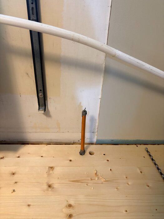 En träregelvägg med kopparrör och kabelgenomföring i ett pågående rörinstallationsarbete.