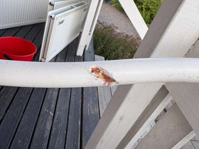 Ett prisolrör med en synlig skada där kopparn är exponerad, vilket pekar på en möjlig framtida vattenläcka.