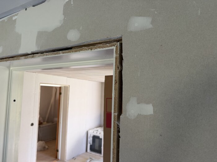 Gipsskiva runt fönster eller dörr, där karmen sitter för djupt pga nytillägg av gips, vilket orsakar problem vid montering av foder. Renovation pågår.