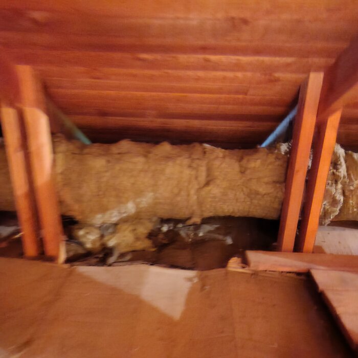 Isolerat ventilationsrör i en vind med träbalkar synliga, kopplat till tilluftssystemet före FTX.