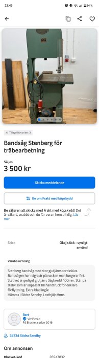 Grön bandsåg av märket Stenberg för träbearbetning, står på trägolv med sladdar hängande på sidan i en verkstadsmiljö.
