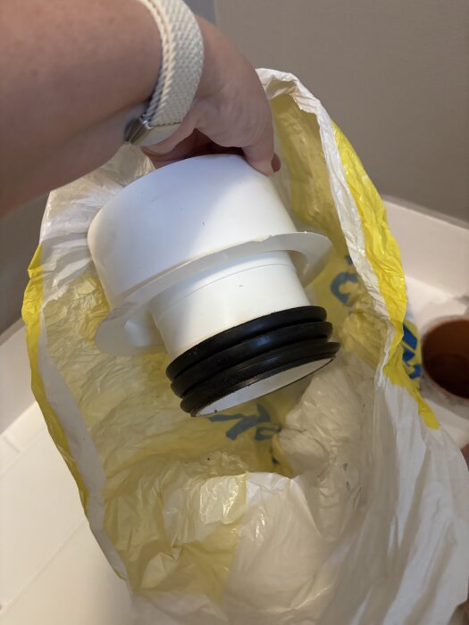 Vit plaststos med svart gummitätning visad i en plastpåse, en del av en diskussion om avloppsanslutning vid installation av IFÖ Silia.