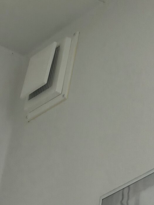 Ventilationsöppning på väggen ser ut att vara igensatt eller delvis blockerat, ifrågasättande av dess funktionalitet.