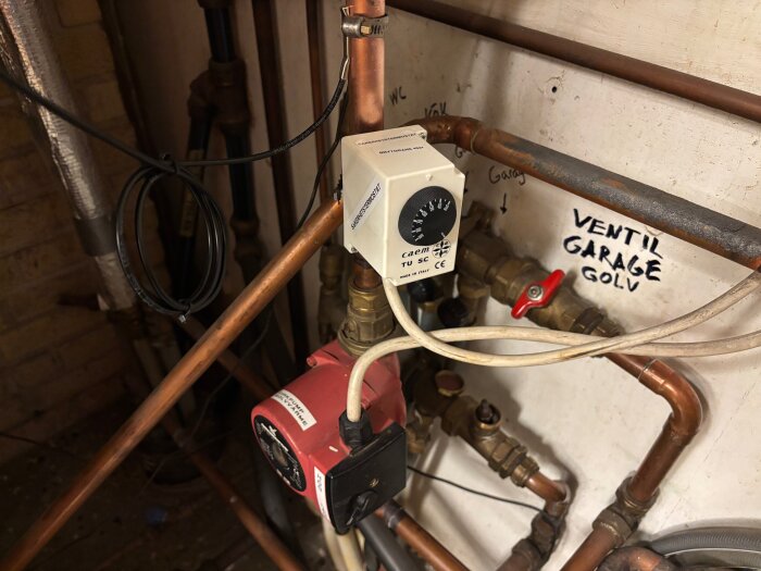 Shuntautomatik och rörsystem i ett garage med en ny ESBE CRA211 regulator installerad. Till vänster finns en säkerhetstermostat monterad.