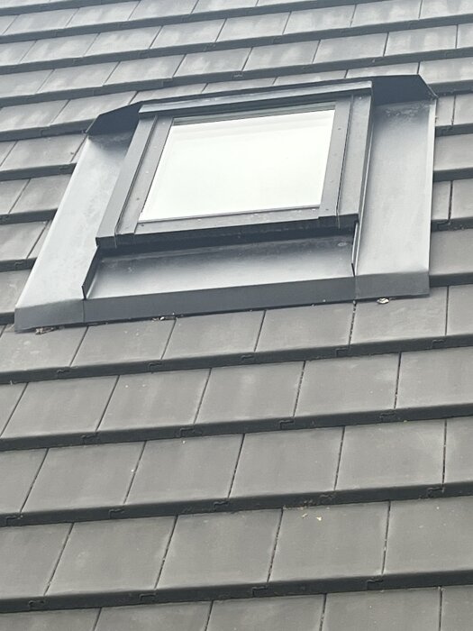 Tak med betongpannor och ett takfönster.