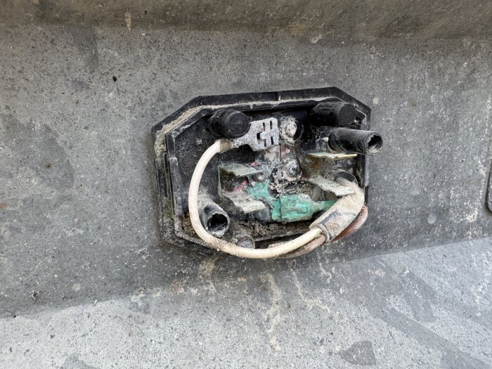 Korroderad elektronikdel i ett släp vars frampositionsljus har slocknat efter 4 år utomhus.