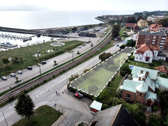 Flygbild över ett bostadsområde nära havet, med markering av privat trädgård som kan göras om till gång- och cykelväg.